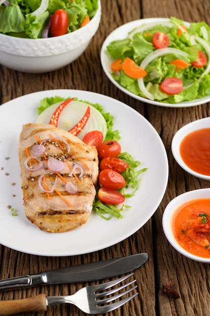 Gegrilltes hähnchen auf einem weißen teller mit tomaten, salat ...