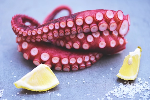 Gekochte tintenfischtentakeln mit zitrone auf teller, octopus food ...