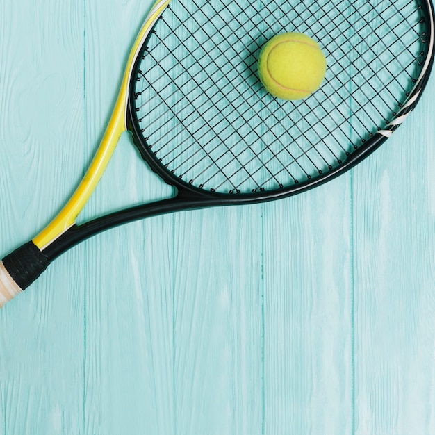 Gelber ball, der auf tennisschläger liegt | Kostenlose Foto