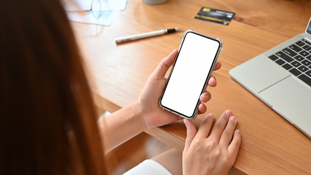 Geschäftsfrau, die smartphone auf schreibtisch verwendet Premium Fotos