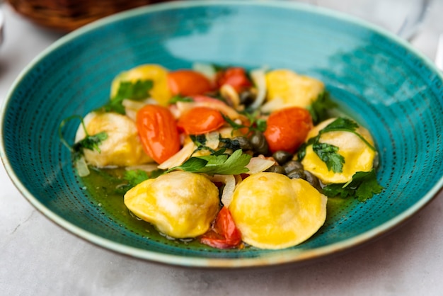 Geschmackvolle ravioliteigwaren in der grünen keramischen platte Kostenlose Fotos