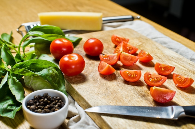 Geschnittene kirschtomaten auf einem hölzernen hackenden brett. Premium Fotos