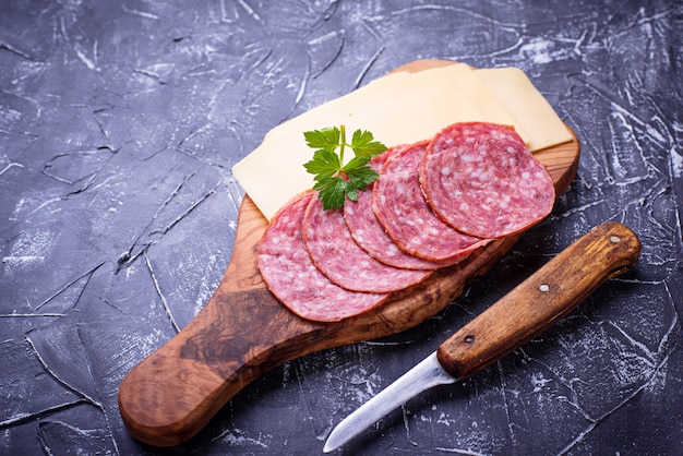 Geschnittener käse und salami auf holzbrett | Premium-Foto