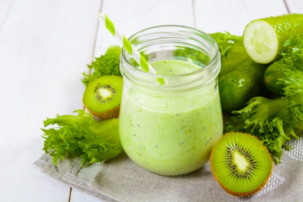 Gesunder grüner smoothie im glas mit gurke, kiwi, salat | Premium-Foto