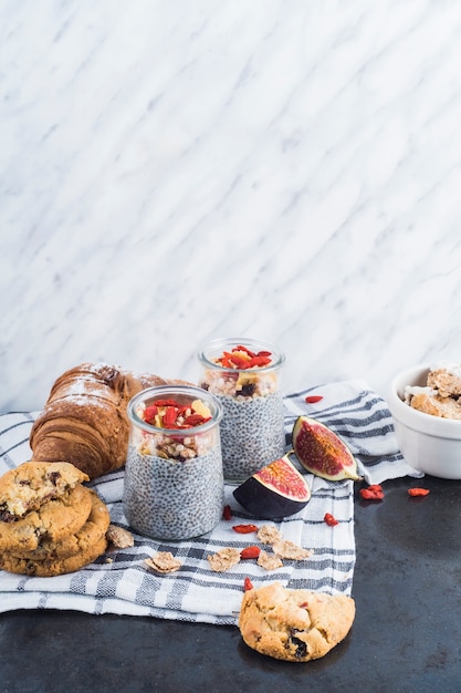 Gesunder smoothie mit unterstützten plätzchen und hörnchen auf serviette gegen strukturierten marmorhintergrund Kostenlose Fotos
