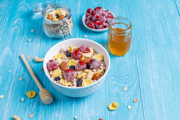 Gesundes frühstück. frisches müsli, müsli mit nüssen und gefrorenen ...