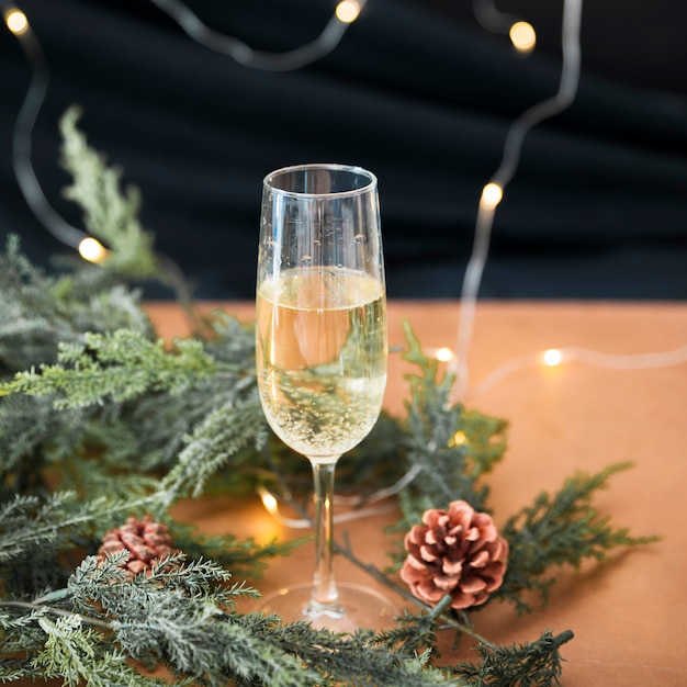 Glas champagner mit grünen zweigen Kostenlose Foto