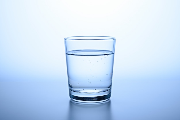 Glas klares wasser auf blauem hintergrund | Premium-Foto