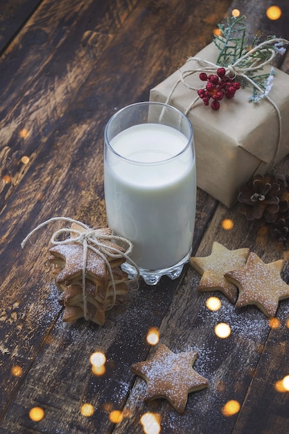 Glas milch und weihnachtsplätzchen auf braunem holztisch