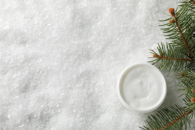 Glas wintercreme für haut auf schnee, platz für text