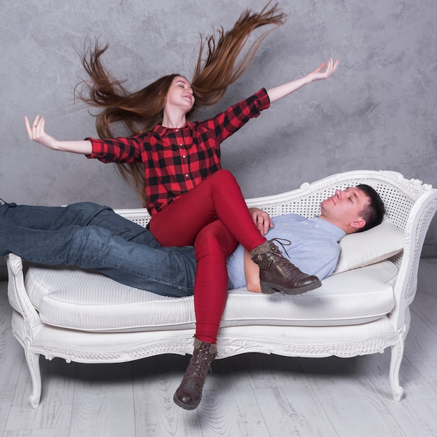 Glückliche frau, die auf mann auf sofa sitzt Kostenlose Foto