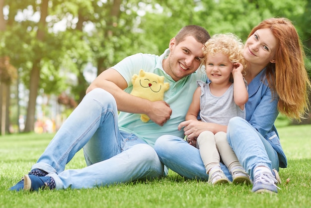 Glückliche junge familie, die am park sich entspannt Premium Fotos