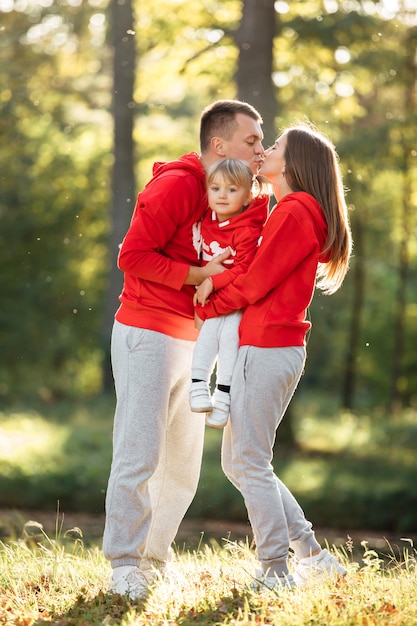 Glückliche junge familie im herbstpark. mama, papa und kleine tochter