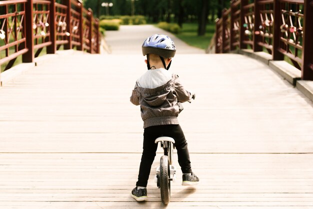 Glücklicher kleiner junge, der ein fahrrad fährt, das im