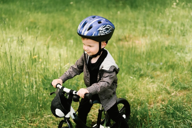 Glücklicher kleiner junge, der ein fahrrad fährt, das im