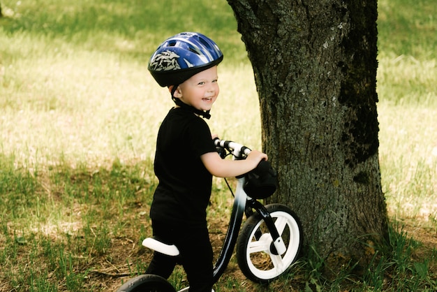 Glücklicher kleiner junge, der ein fahrrad fährt, das im