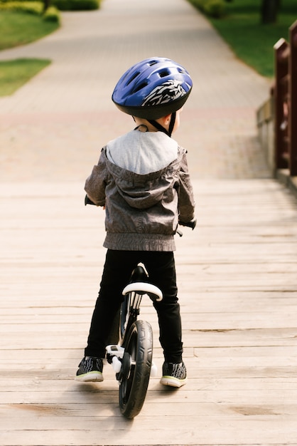 Glücklicher kleiner junge, der ein fahrrad fährt, das im