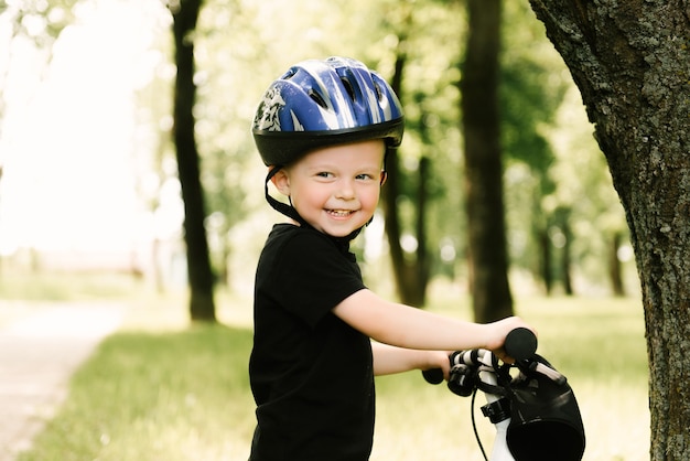 Glücklicher kleiner junge, der ein fahrrad fährt, das im