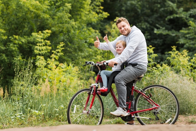 Glücklicher vater und tochter auf fahrrad Kostenlose Foto