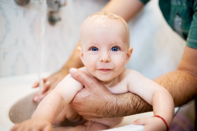 Glückliches lachendes baby, das ein bad nimmt. kleines ...