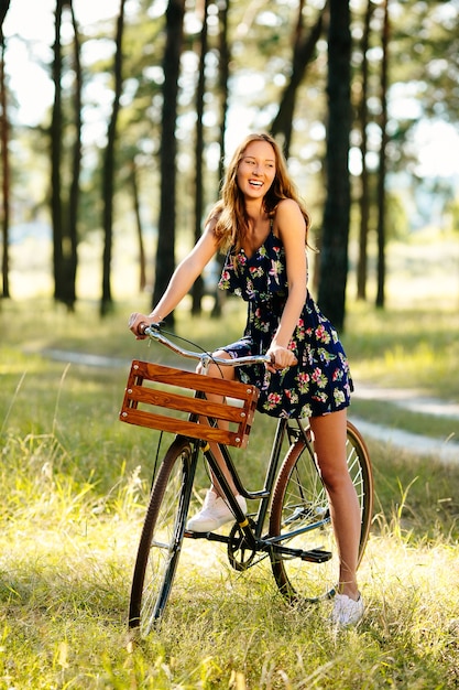 Glückliches mädchen auf einem fahrrad im wald