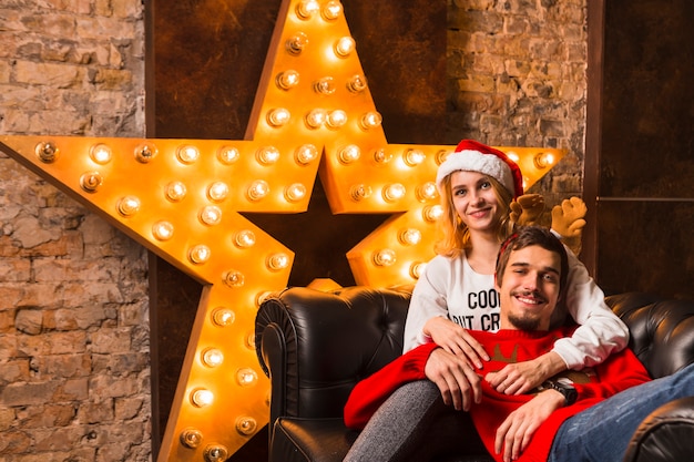 Glückliches paar vor weihnachtssterndekoration | Kostenlose Foto