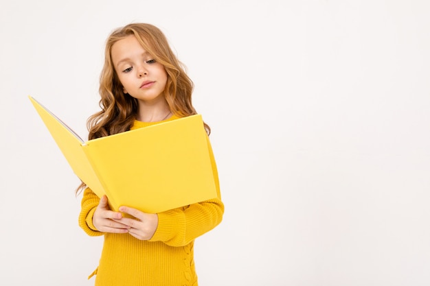 Gluckliches Teenager Madchen Mit Roten Haaren Kapuzenpulli Und Gelben Hosen Lesen Grosses Gelbes Buch Das Auf Weiss Isoliert Wird Premium Foto