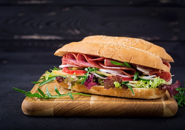 Großes sandwich mit schinken, salami, tomate, gurke und kräutern ...