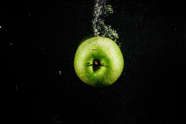 Gruner Apfel Spritzt Wasser Auf Schwarzem Hintergrund Fallen Kostenlose Foto