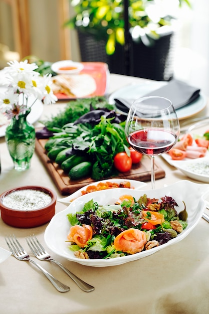 Grüner salat mit kräutern und einem glas rotwein. Kostenlose Fotos