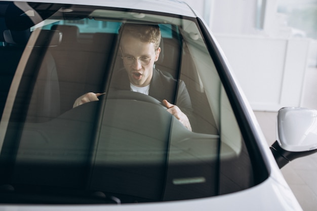 Gut aussehender mann, der in einem auto sitzt Kostenlose Fotos