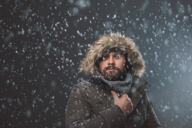 Gut aussehender mann im schneesturm Kostenlose Fotos