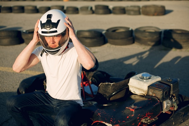 Gut aussehender mann in einem kart mit einem auto Kostenlose Fotos