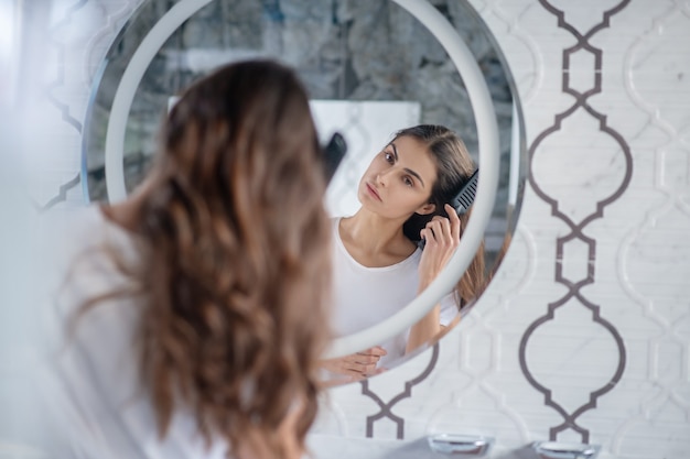 Haare Kammen Eine Frau Kammt Ihre Haare In Der Nahe Des Spiegels Premium Foto