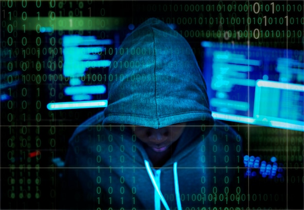 Hacker in einem kapuzenpulli mit computerhintergrund | Premium-Foto