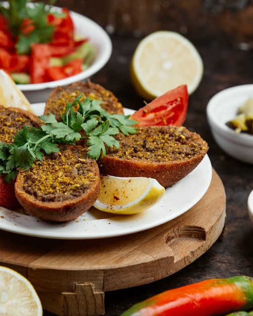 Hackfleisch in gebratenem brot mit zitronenscheiben und tomaten ...