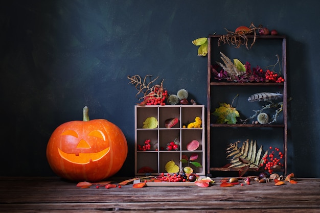 Halloween-kürbis mit natürlichen herbstdekorationen auf dunklem