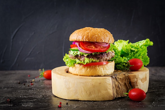 Hamburger mit rindfleischburger und frischem gemüse auf dunklem tisch ...