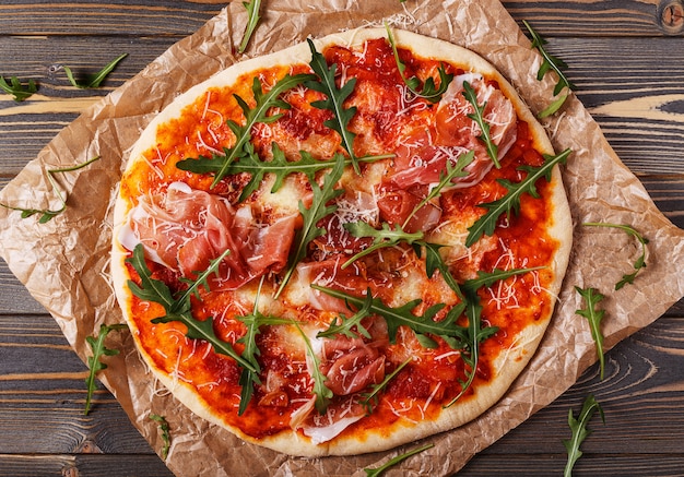 Hausgemachte pizza mit schinken und rucola. | Premium-Foto