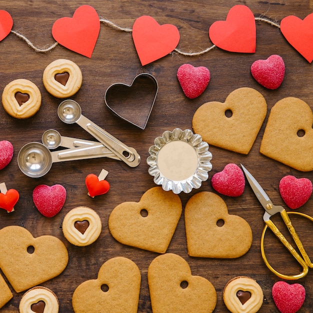 Herz kekse und süßigkeiten in der nähe von backformen | Kostenlose Foto