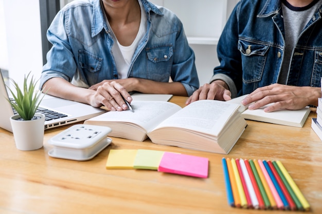 Highschool tutor- oder student-gruppe, die am schreibtisch in der studierenden und lesenden bibliothek sitzt und hausaufgaben und lektion tut, die prüfung auf eingang vorbereiten Premium Fotos