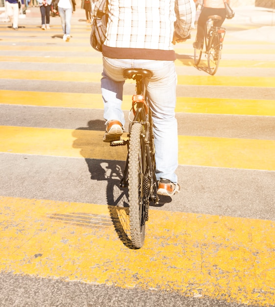 Hintere ansicht einer person, die fahrrad auf gelben