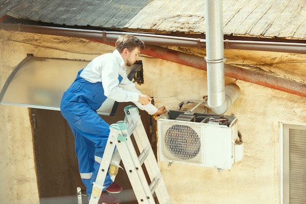 Kostenlos Foto Hlk Techniker Der An Einem Kondensatorteil Fur Die Kondensationseinheit Arbeitet Mannlicher Arbeiter Oder Handwerker In Einem Einheitlichen Reparatur Und Einstellkonditionierungssystem Das Technische Probleme Diagnostiziert Und Sucht