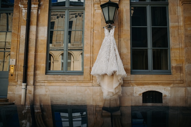 Hochzeitskleid, das an der straßenlaterne hängt ...