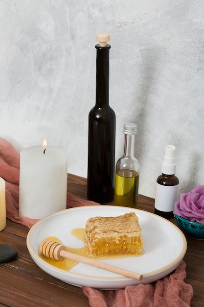 Hölzerner schöpflöffel und keramische weiße platte mit flasche des ätherischen öls auf holztisch Kostenlose Fotos