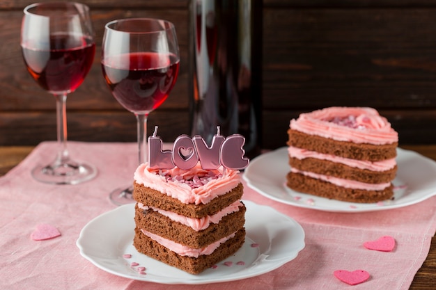 Hoher winkel der herzförmigen kuchenscheiben mit weingläsern Kostenlose Fotos