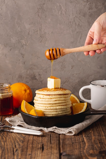 Honig tropft vom löffel über pfannkuchen | Kostenlose Foto