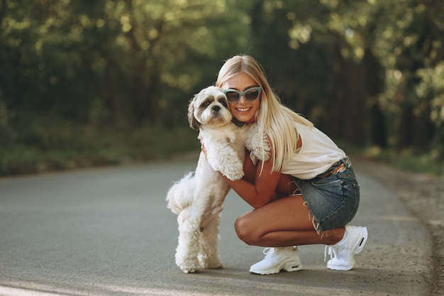 Hübsche frau mit ihrem hund im park Kostenlose Foto