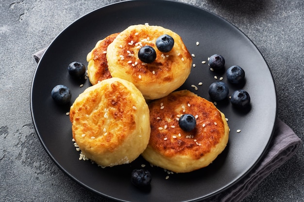 Huttenkase Mit Blaubeeren Kasebruch Kasekuchen Pfannkuchen Auf Einem Dunklen Betontisch Speicherplatz Kopieren Premium Foto