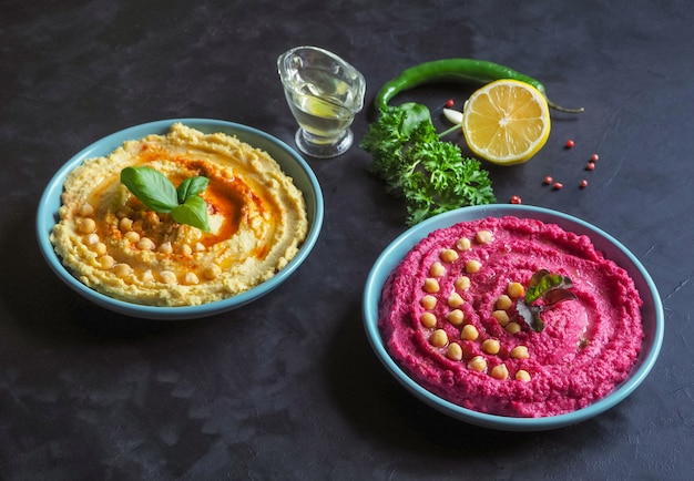 Hummus mit rote beete und traditionellem hummus auf einem schwarzen ...